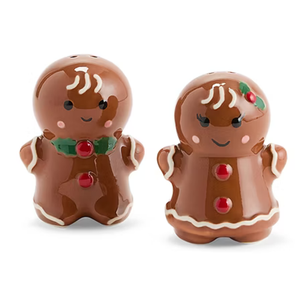 Gingerbread man and woman salt and pepper shakers with red button details, green holly accents, and white icing-like trim.