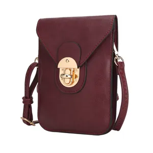A burgundy crossbody bag with a gold clasp, featuring a textured strap and stitched detailing.