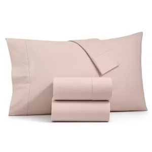 A set of light pink bed sheets with two pillowcases.