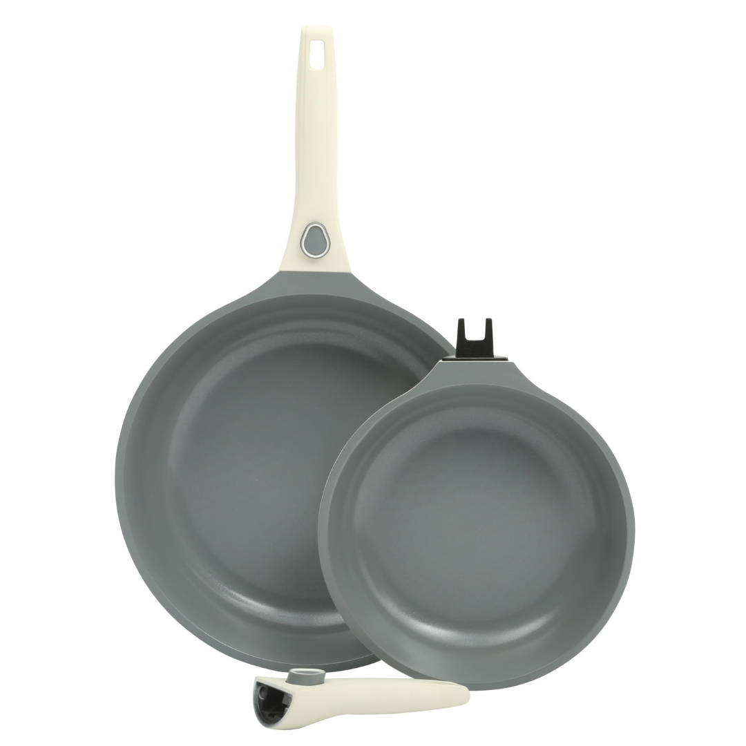 Two non-stick frying pans with gray interiors and white handles, one of which is detachable.