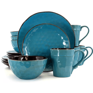 A 16-piece dinnerware set in glossy blue ceramic with a subtle textured finish, featuring plates, bowls, and mugs.