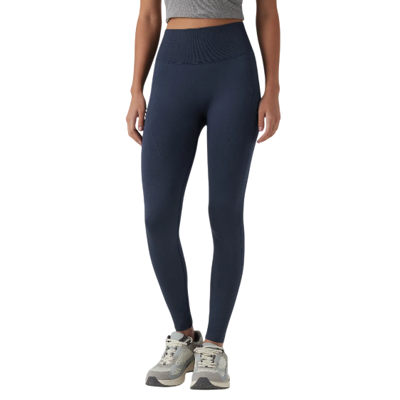 A person is wearing high-waisted, navy blue leggings paired with gray sneakers, standing against a plain background.