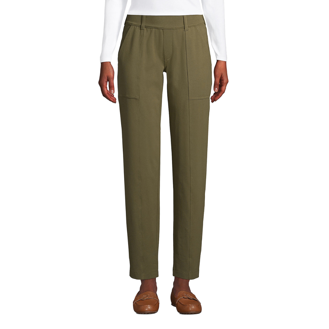 Olive green trousers with front seams and side pockets paired with brown loafers.