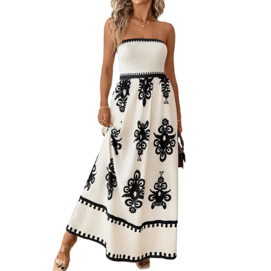 A strapless, white maxi dress with black geometric patterns and a fitted waist. The dress features decorative trim details and is worn with open-toed platform sandals.