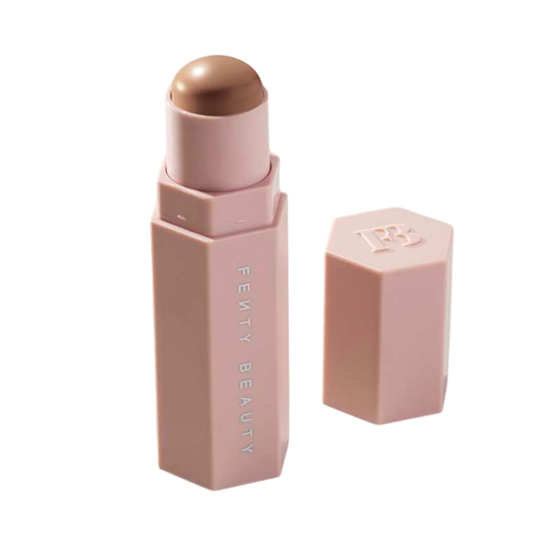 A Fenty Beauty stick in a hexagonal tube with a brown shade and a matching removable cap, displayed on a neutral surface.