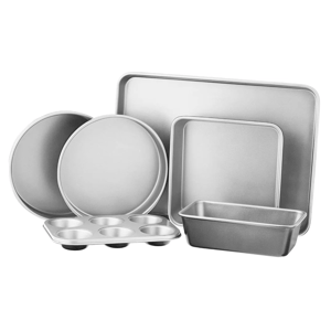 A set of baking pans includes a muffin tin, two round cake pans, a loaf pan, a square pan, and a rectangular baking sheet, all made of silver metal.