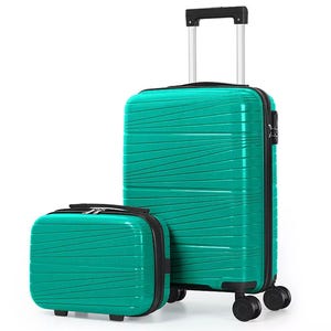 A turquoise hard-shell suitcase with wheels and a matching smaller travel bag, both featuring textured diagonal lines and a black handle on the suitcase.