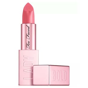 A pink lipstick from Too Faced, featuring a design with \“LADY\“ and \“BOLD\“ embossed on the case in a metallic finish.