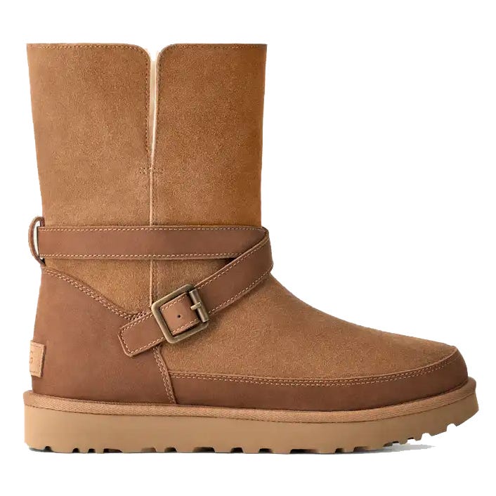 A brown suede mid-calf boot with a decorative strap and buckle design, featuring a flat outsole for stability and comfort.