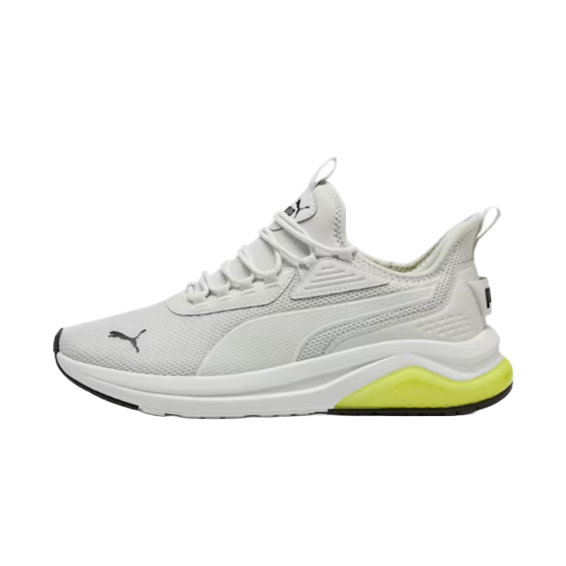 White Puma sneakers with a mesh upper, lace-up design, and a distinctive yellow accent on the midsole. Features include a sleek silhouette, subtle branding, and a textured sole for grip.