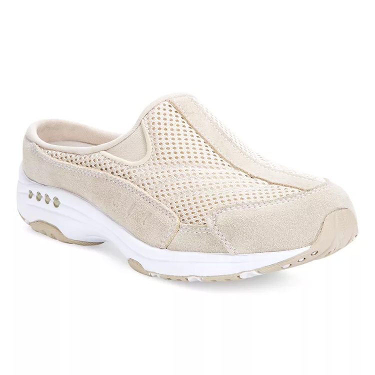 Easy Spirit Slip-On Mule Sneakers feature a beige color, mesh upper for breathability, and a cushioned white sole for comfort. They have a slip-on design with a low back for easy wear.