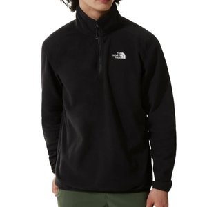 A person is wearing a black North Face fleece pullover with a half-zip and logo on the chest. The pullover is paired with green pants.