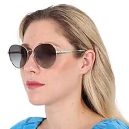 A woman wearing large, round sunglasses with a metallic frame and dark lenses, paired with a blue top.