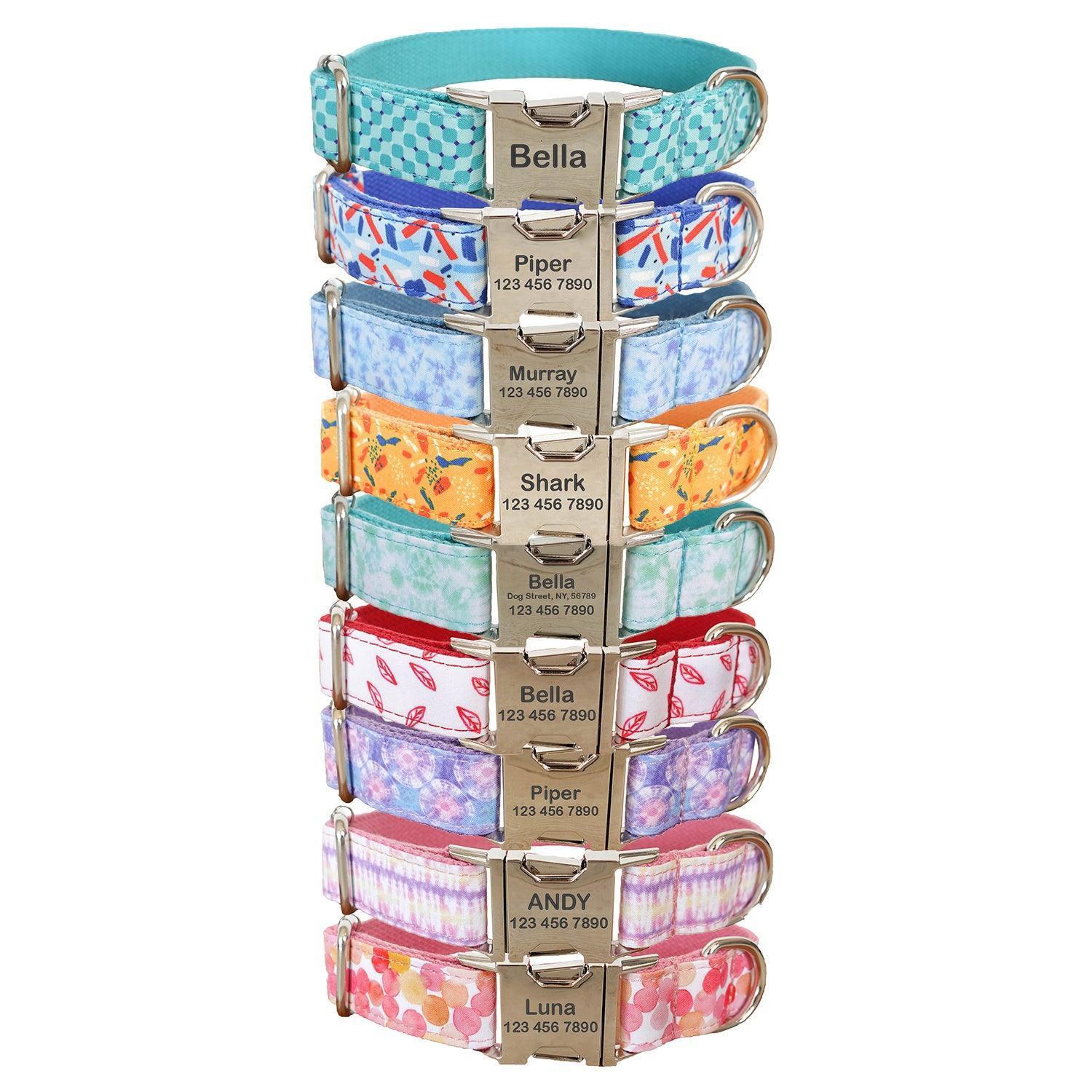 A stack of colorful pet collars with metal buckles engraved with pet names and contact numbers, featuring various patterns such as checkered, floral, and abstract designs.