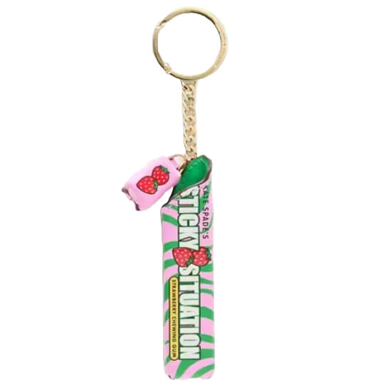 Kate Spade Bubble Gum Bag Charm features a pink and green striped design with \“A Sticky Situation\“ text and strawberry graphics, including a small pink charm with strawberries, all attached to a gold key ring with a chain.