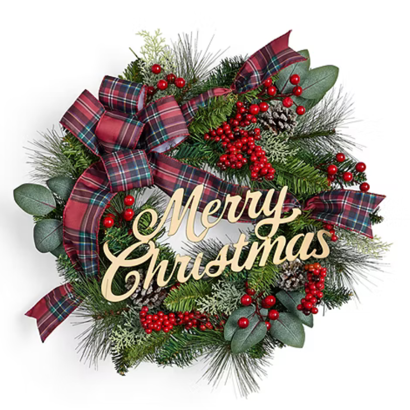 A Christmas wreath features red berries, green foliage, plaid ribbons, and pinecones with a wooden \“Merry Christmas\“ sign in the center.