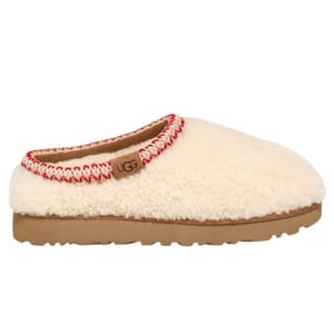 A white fuzzy slip-on shoe with red and white stitching around the top, featuring a brown sole and a small label.