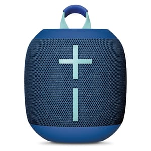 A portable blue Bluetooth speaker with a fabric mesh exterior, featuring large plus and minus buttons on the front for volume control and a handle at the top.
