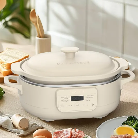 A 4-quart capacity cooking appliance with a digital interface, suitable for tasks like slow cooking and rice preparation, is set on a kitchen counter surrounded by food items.