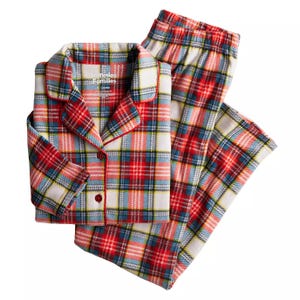 Plaid flannel pajamas in red, blue, yellow, and white with a button-up shirt and pants, featuring a collar and piping details.