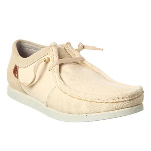 Beige casual shoe with a moc toe design, featuring a fabric upper, lace detailing, and a flat white sole.
