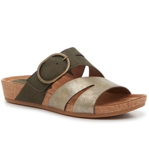 A wedge sandal with a cork sole features a criss-cross strap design in olive green and metallic gold, accented by a large decorative buckle.