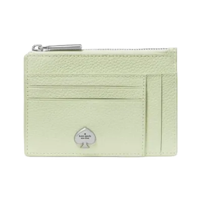 A light green leather card holder with multiple card slots, a zippered compartment, and a metal spade logo in silver at the front.