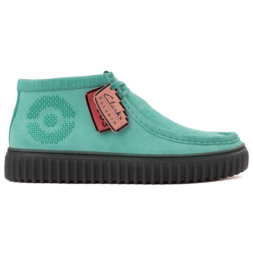 A turquoise Clarks shoe featuring a textured circle design on the side, with a black ribbed sole, and hanging tags displaying the collaboration with Pokémon.
