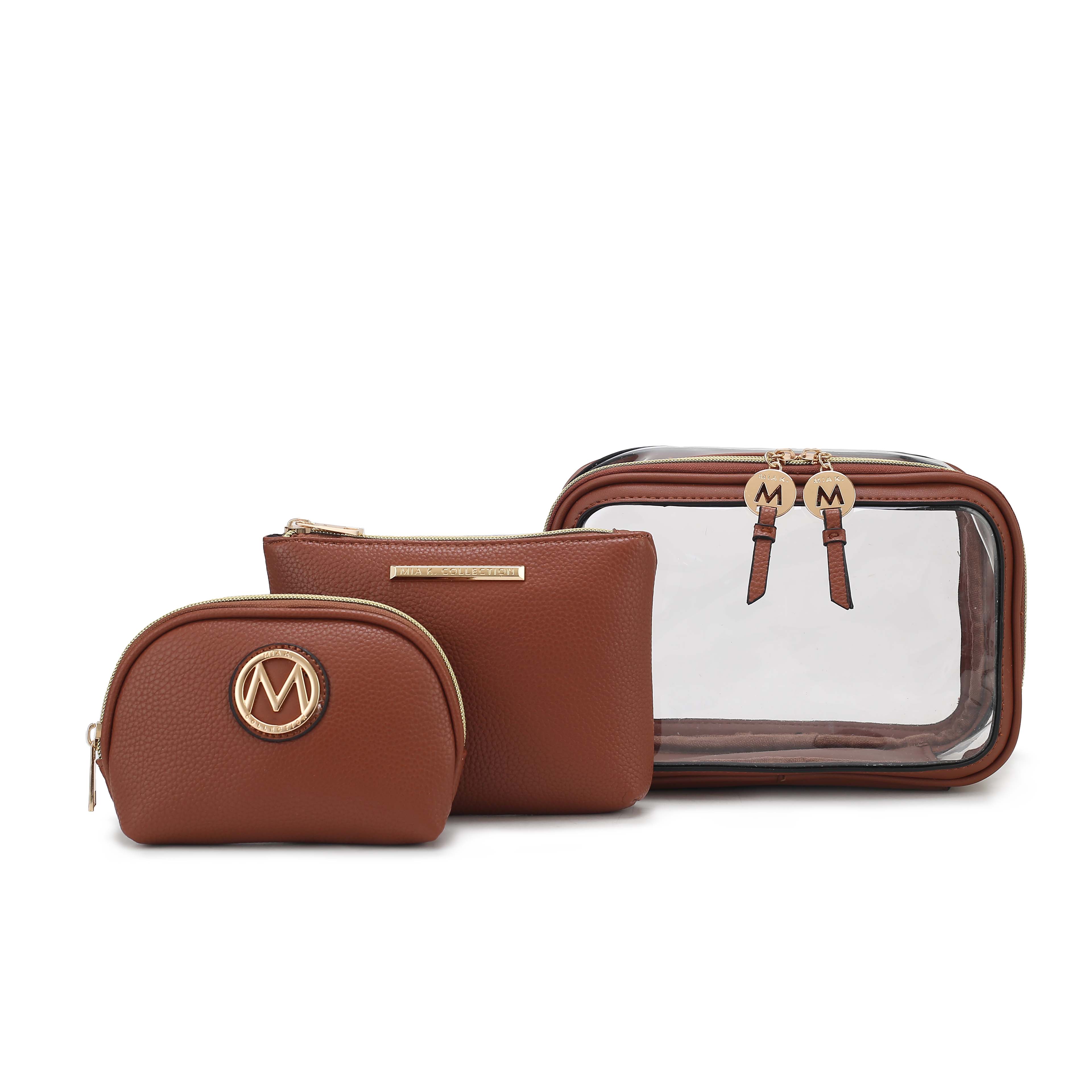 A set of three brown cosmetic bags, including a small pouch with a gold \“M\“ logo, a medium pouch with a gold label, and a large pouch with a clear front and dual zippers, each featuring a gold medallion with an \“M.\“