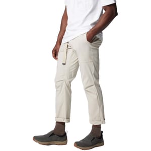 A man wearing a white T-shirt, beige cargo pants with a side pocket, and gray slip-on shoes with brown socks.