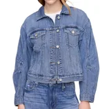 A blue denim jacket with front button closure, chest pockets, and seam detailing, paired with matching blue denim jeans.