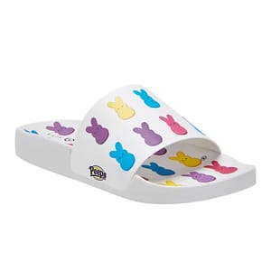 A pair of white slide sandals adorned with colorful bunny-shaped logos from the Peeps candy brand.