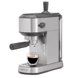 Espresso machine by Calphalon, featuring a portafilter handle, steam wand, and a removable water tank. A glass cup with espresso is placed on the drip tray.