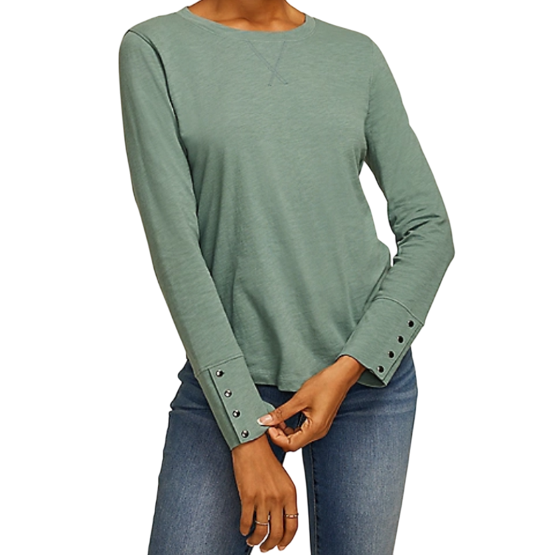Green long-sleeve shirt with decorative buttoned cuffs and a subtle V-stitch detail at the neckline, paired with blue jeans.