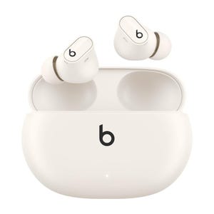 White wireless earbuds with a charging case featuring the Beats logo.