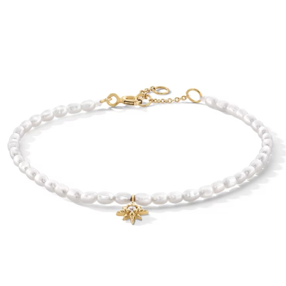 A pearl necklace with a gold star-shaped pendant and a gold chain clasp.