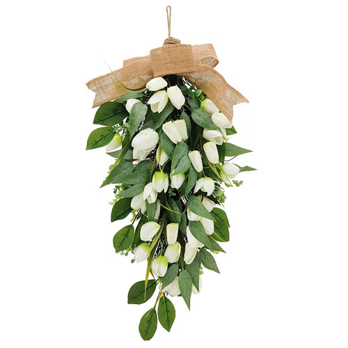 A hanging floral arrangement featuring white tulip-like flowers with green leaves, tied with a burlap ribbon at the top.