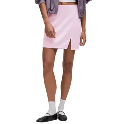 A person is wearing a light pink mini skirt with a front slit, paired with white socks and black ballet flats. A portion of a purple jacket is visible at the top.