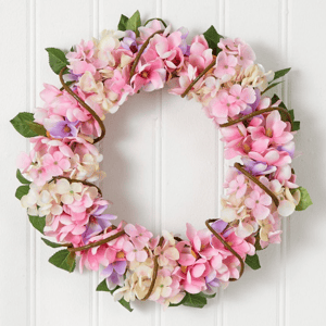 A floral wreath composed of pink and white hydrangea blooms with green leaves.