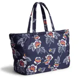 A floral-patterned tote bag with navy background, featuring vibrant flowers and leaves. It has two matching handles, offering a stylish design for carrying essentials.