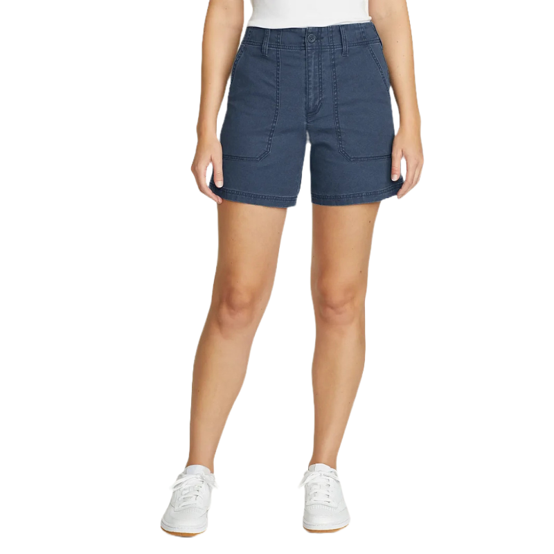 A person is wearing dark blue denim shorts with visible stitching, paired with a white top and white sneakers.