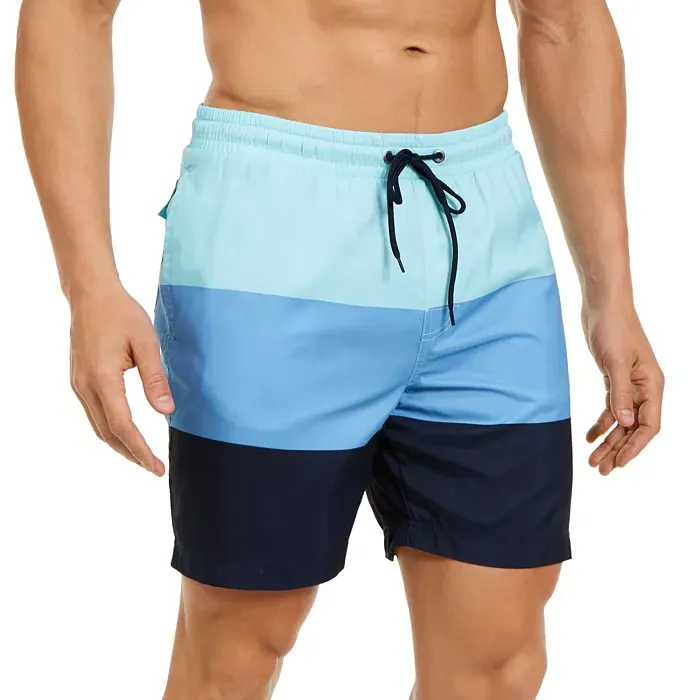 A man wearing blue gradient swim shorts with a drawstring waist.