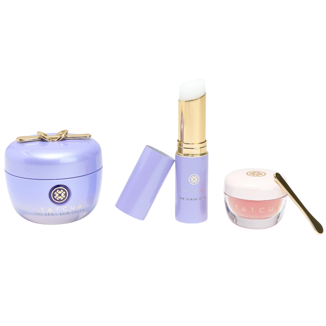 Tatcha skincare items featuring The Dewy Skin Cream, The Serum Stick, and The Kissu Lip Mask with a gold spatula, all in sleek packaging with lavender and pink tones.