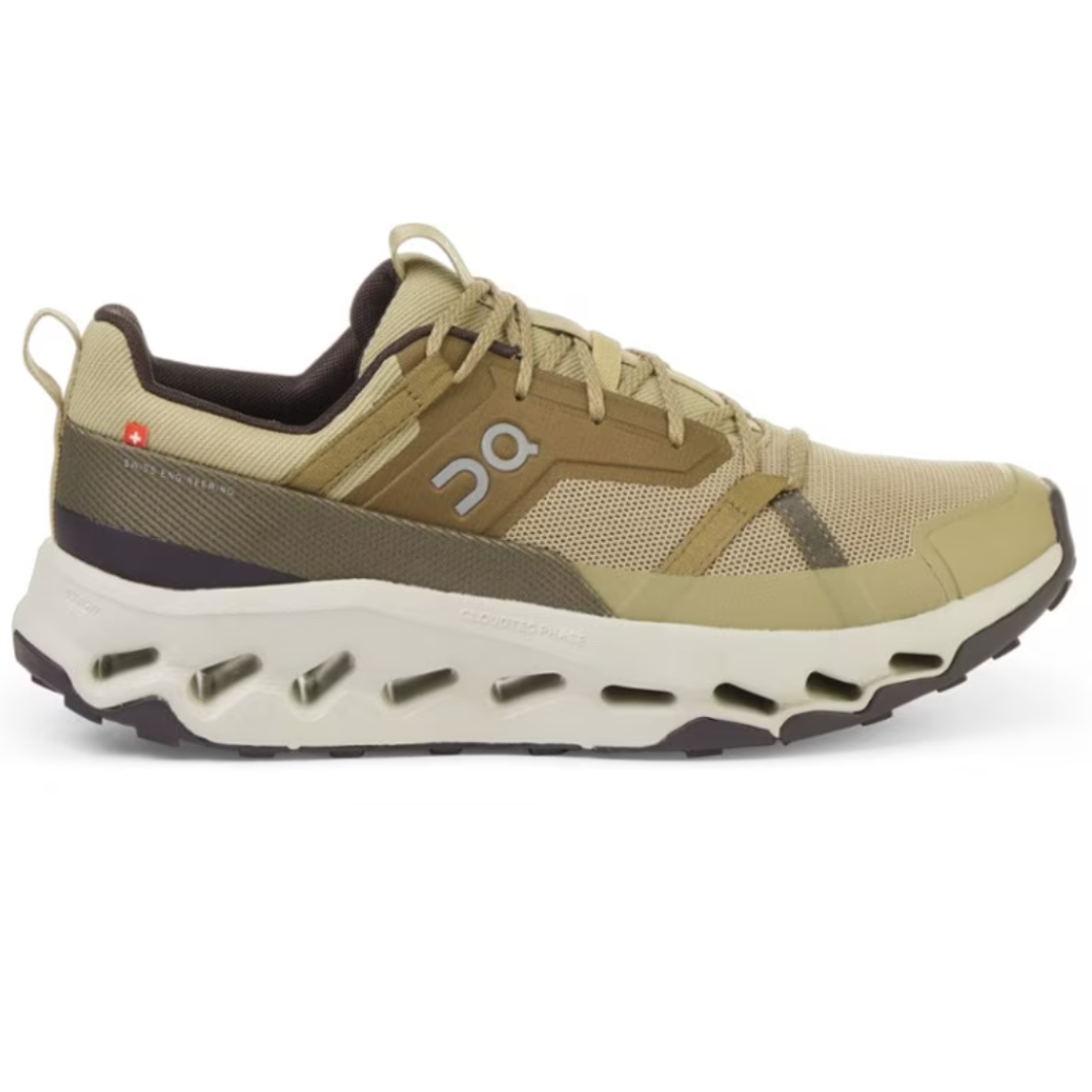 On Men's Cloudhorizon Hiking Shoes are tan with a mesh upper and reinforced overlays. They have a cushioned sole with signature CloudTec technology for comfort and grip, and feature a loop at the heel for easy wearing.
