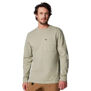 A man wearing a light green long-sleeve shirt with a small pocket on the chest and tan pants.