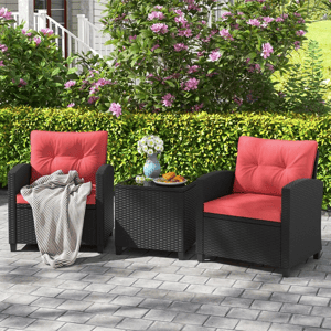 The 3-piece patio conversation set features two black rattan armchairs with red cushions and a matching square side table. The chairs include plush padding, and the set is designed for outdoor use on patios or gardens.