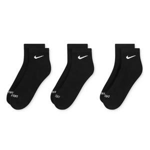 Three pairs of black ankle socks with white Nike logos and \“DRI-FIT\“ text near the toes.