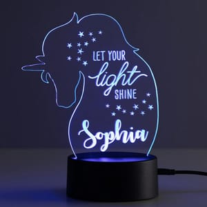 A unicorn-themed LED night light displays the phrase \“Let Your Light Shine\“ and the name \“Sophia,\“ with stars around the text.