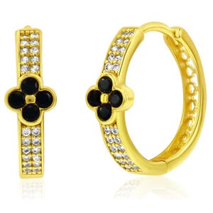 Gold hoop earrings featuring black flower-shaped accents and rows of small, clear stones.