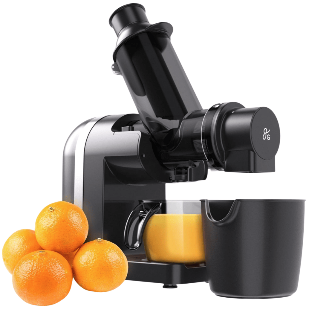 A black juicer machine with a glass of orange juice next to a container and four oranges.